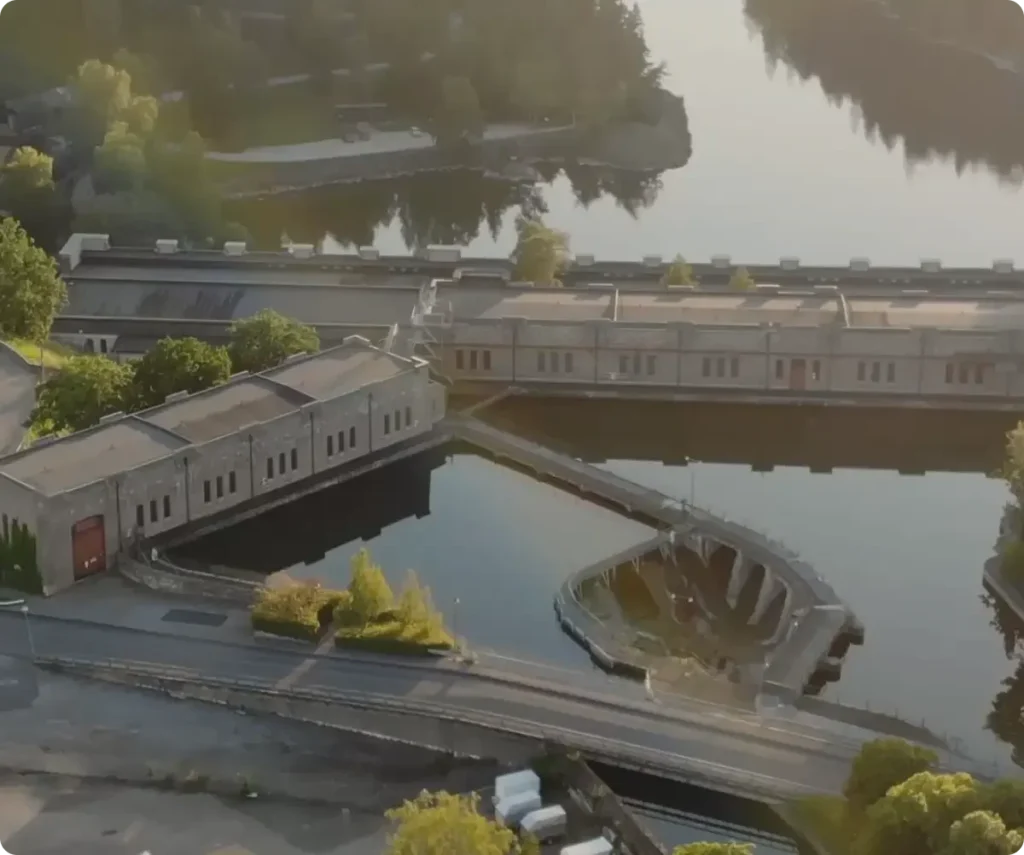Drone view of a facility surrounded by water and greenery